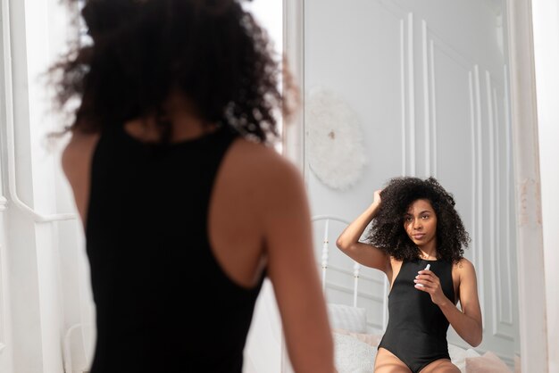 woman wear shaping bodysuit looking mirror